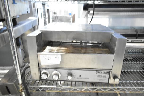 Holman countertop electric conveyor oven, stainless steel, used condition. Features control knobs and visible Holman branding.