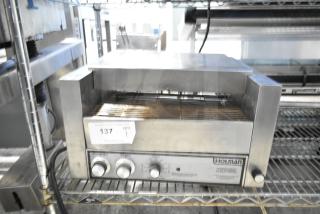Holman countertop electric conveyor oven, stainless steel, used condition. Features control knobs and visible Holman branding.