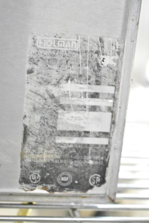 Holman Countertop Electric Powered Conveyor Oven with weathered label showing brand and certification markings.