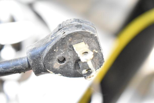 Close-up of a plug from a Juice Tree 105 Commercial Citrus Juicer, showing wear. 115V, 1 Phase, for commercial use.