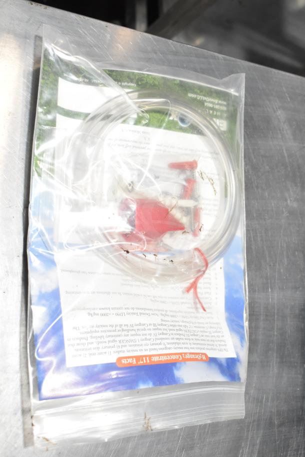 Blend Buddy Wall Mounting Dispensing System, sealed in clear plastic bag, includes tubing and red connectors, new condition.