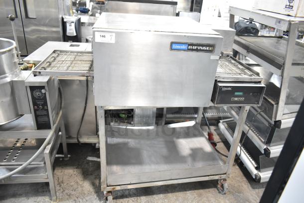 Lincoln Impinger commercial conveyor pizza oven on stand, stainless steel finish, visible brand label, used condition.
