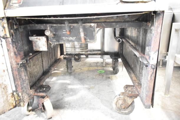 BKI FKM-F commercial electric pressure fryer on casters, shows signs of use, 208/230 volts, 3 phase, visible wear.