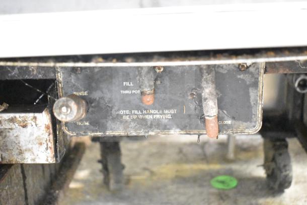 BKI FKM-F commercial electric pressure fryer on casters, uses 208/230V, 3-phase. Visible use marks, fill handle instructions shown.