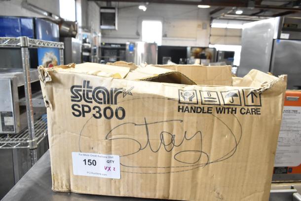 Cardboard box labeled "Star SP300" in warehouse, contains items including a Belshaw TG50 soap dispenser. Box shows wear.