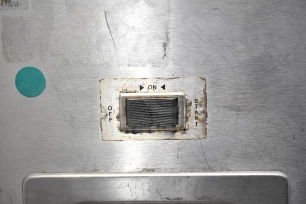 Rusted switch panel of a Bunn G9 commercial coffee grinder, showing on/off/start labels, indicating used condition.