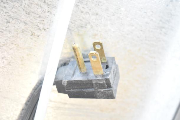The image shows a close-up of a three-prong electrical plug relevant to the Whirlpool WRT511SZDM00 Reach In Cooler.