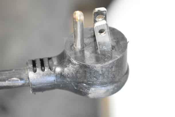Close-up of a power plug for a 2025 True TSCI-600R-G-PH commercial cooler, showing standard three-prong design.