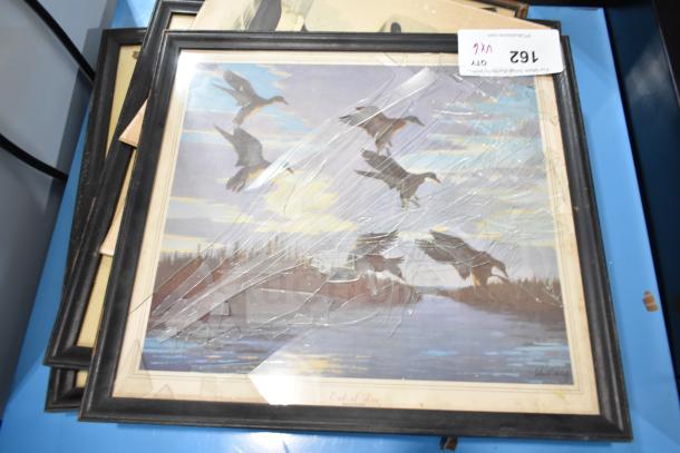 Framed picture featuring flying birds at sunset; glass cover is cracked. Includes various items like The Book of Kells. Lot marked 162.