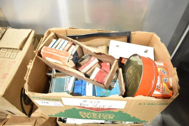 Lot of automotive items including Fram PH4967 Extra Guard and Napa Thermostat, various boxes and labels visible, mixed condition.