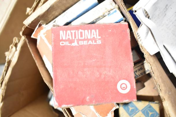 Lot of various auto parts including a National Oil Seals box. Items appear used, condition varies. Includes Fram PH4967, Napa Thermostat.