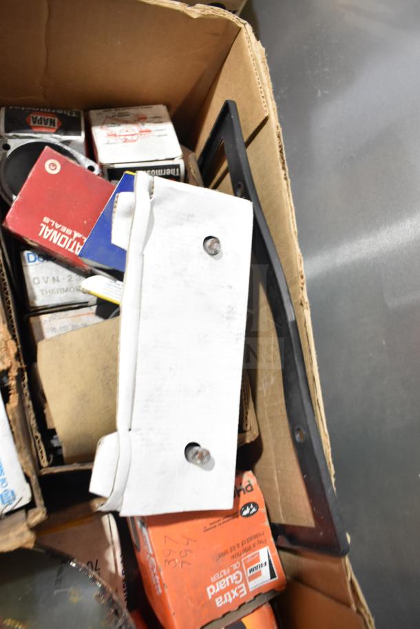 Lot of various automotive items in a box, includes Fram PH4967 Extra Guard oil filter, Napa thermostat, assorted packaging.
