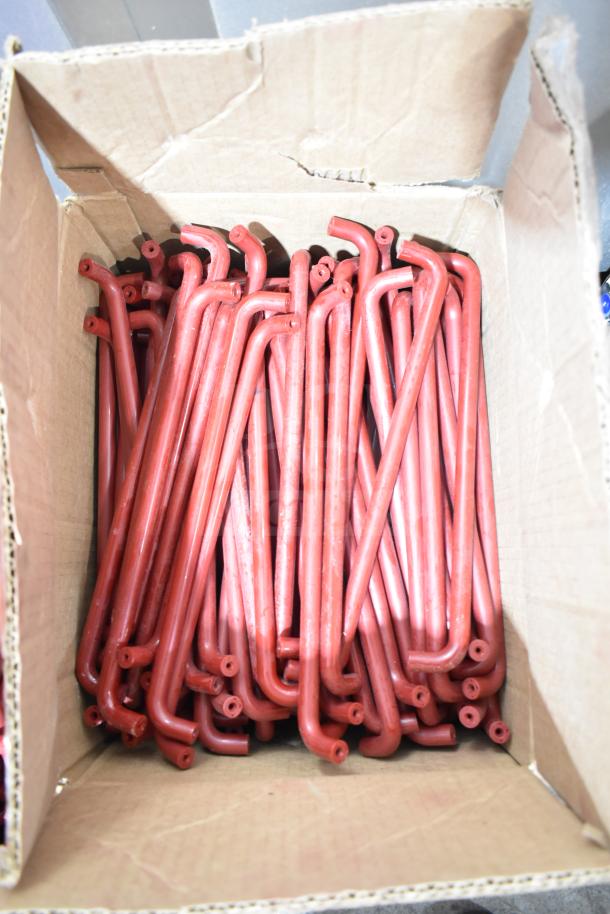 Lot of red L-shaped pieces in a cardboard box; likely used for hardware or assembly purposes. Good condition.
