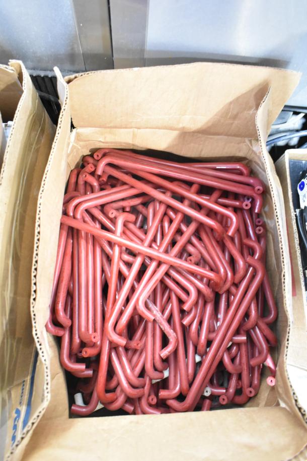 Lot of 4 boxes with red metal pieces. Pieces are curved, in good condition, packed in a cardboard box.