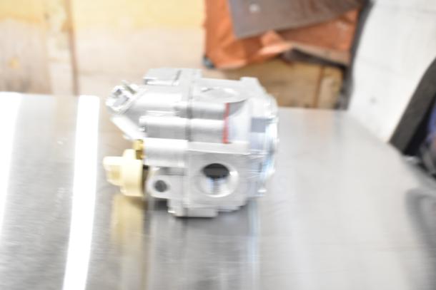 Blurred image of a mechanical component, possibly a Robertshaw 7000BMSGOR thermostat, metallic finish, new condition.