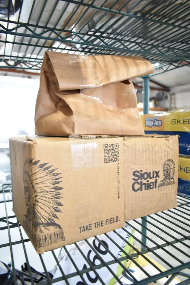 Brown paper bag and Sioux Chief box on wire shelf in warehouse. Box label: Sioux Chief, QR code, "Take The Field". Items inside unidentified.