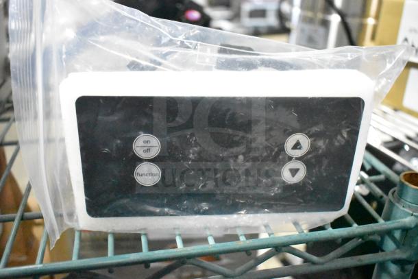 Brand new scratch and dent control box, sealed in plastic, with visible on/off and function buttons for easy operation.