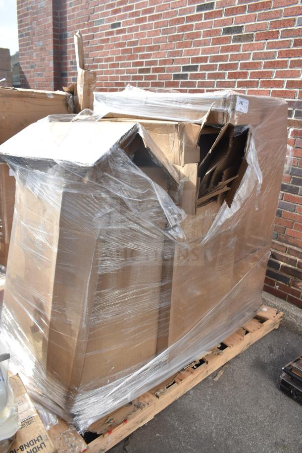 Pallet with four boxed "Scratch and Dent" items, including a barstool, wrapped in plastic, slightly damaged packaging.