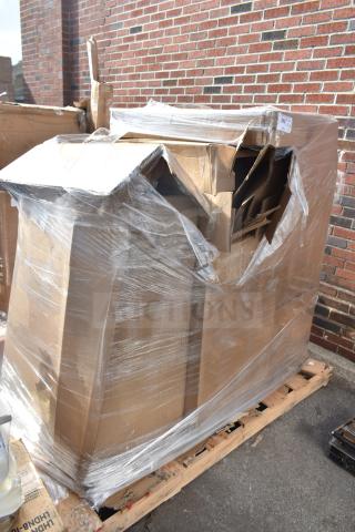 Pallet with four boxed "Scratch and Dent" items, including a barstool, wrapped in plastic, slightly damaged packaging.