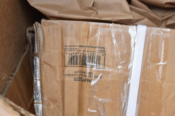 Cardboard box with "USG x 22 Straight Cast Iron Tabe Bar Plate" marking and visible barcode, indicating new scratch and dent items inside.