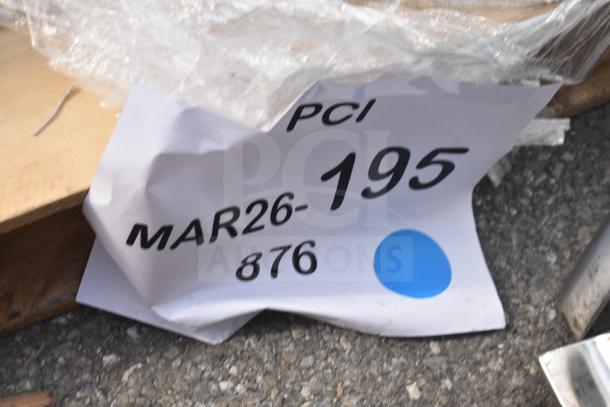 Crinkled auction tag labeled "PCI MAR26-195 876" on a surface with a blue dot marker.