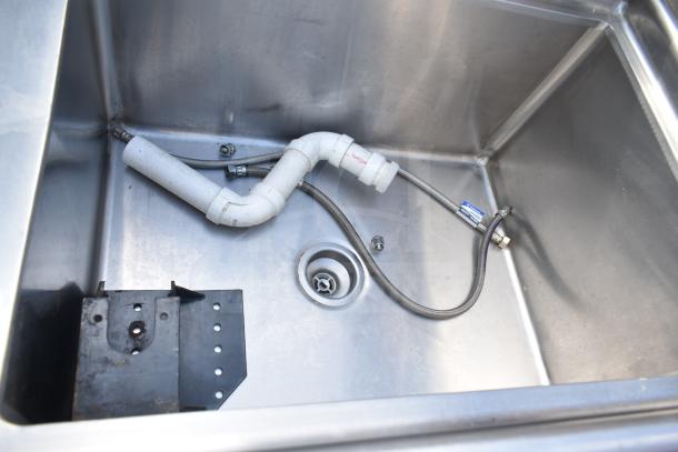 Single bay stainless steel sink with faucet and handles, showing interior plumbing and drain, in used condition.