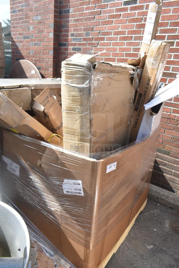 Large cardboard box with various new scratch and dent items inside, including pizza peels and table base pieces. Box labeled "257".