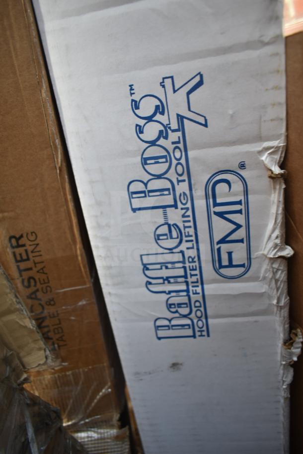 Cardboard boxes labeled "Baffle Boss" and "Lancaster" containing new scratch and dent items, including pizza peels and table bases.