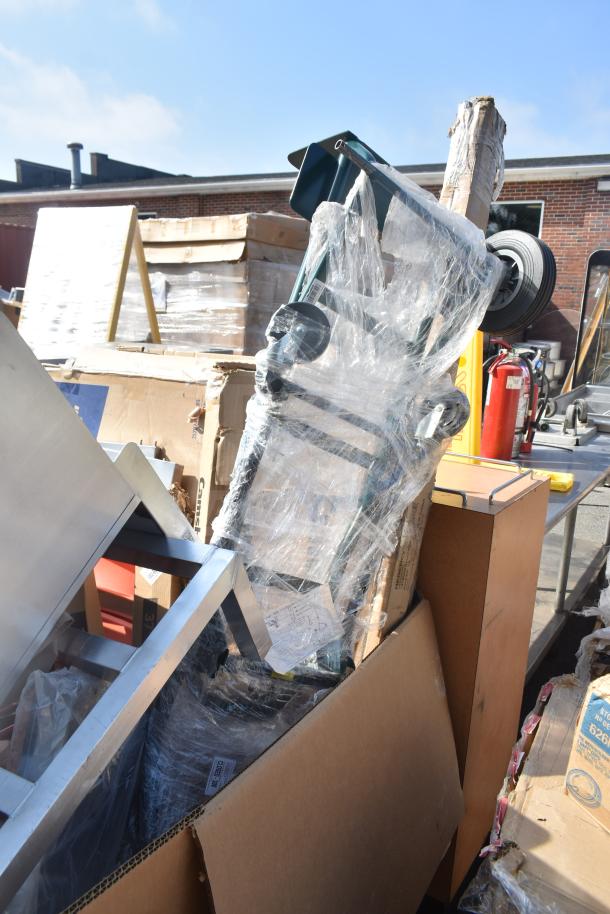 18 new scratch and dent items including a table and sink, wrapped in plastic on a pallet, showing slight packaging wear.