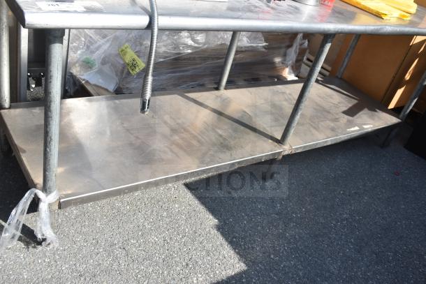 Commercial metal table with shelves, includes fire extinguishers and dolly. Worn condition, visible QR code tag.