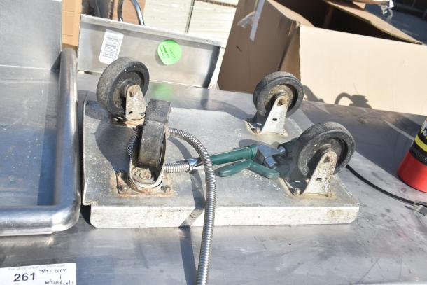 Commercial table with wheels, includes fire extinguishers and dolly, stainless steel, moderate wear, visible inventory tags.