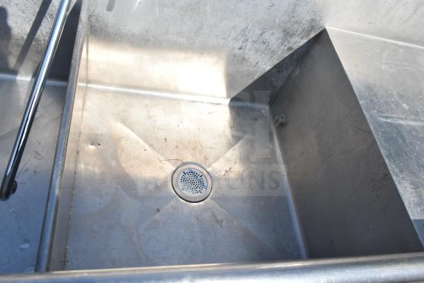 Commercial 2-bay sink with dual drain boards, stainless steel, visible wear, ideal for high-capacity kitchen use.