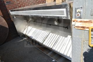 9' commercial grease hood with filters and lights, metallic finish, mounted outdoors, features filtration grates and light fixtures.
