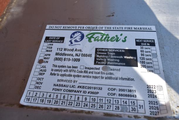 Label on commercial grease hood showing service details for Father's, Middlesex, NJ, with inspection and cleaning records.