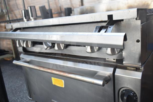 Vulcan commercial gas range with 6 burners and oven, stainless steel, used condition, visible control knobs and oven handle.