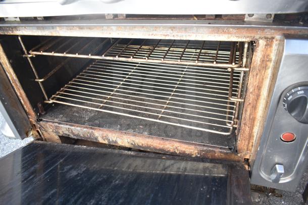 Vulcan commercial gas range and oven with 6 burners, showing interior wear and control knobs on side panel.