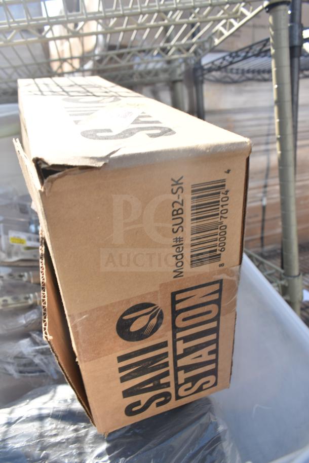 Tan finish 3-tier wire shelving unit with contents. Includes labeled Sani Station box, model SUB2-SK. Buyer must dismantle.