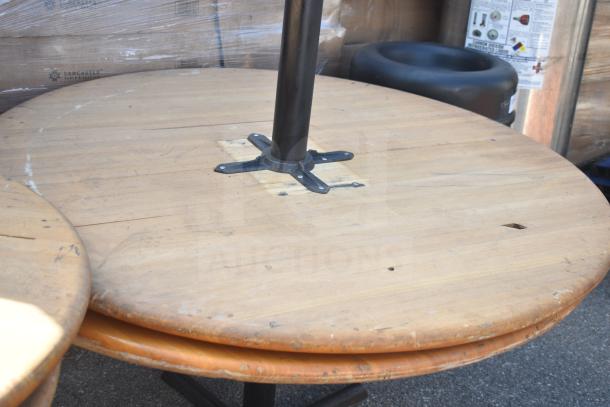 Round wooden tables; three with bases, one missing. Visible wear. Ideal for upcycling or repair.