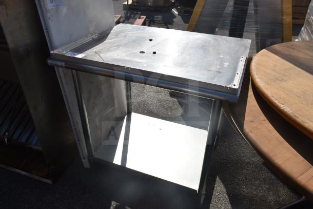 Stainless steel commercial table with under shelf, minor surface wear, sturdy construction, suitable for kitchens or workshops.
