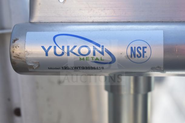 Commercial table label showing "Yukon Metal," model 120-YWTG3036418. NSF certified. Visible scratches on the label.