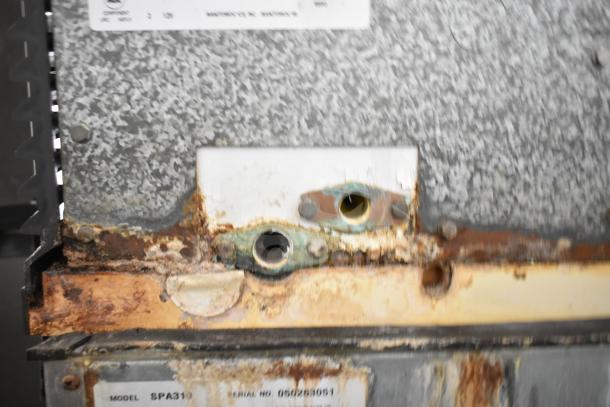 Manitowoc SD0452A ice machine head on hotel dispenser, visible rust and wear, model and serial numbers partially shown.