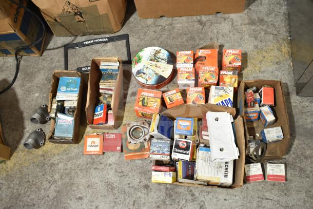 Lot of automotive items including Fram PH4967 Extra Guard filters, Napa and MotoRad thermostats, and towel bars in boxes.