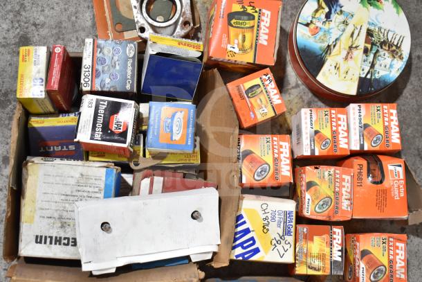 Lot of various items including Fram PH4967 Extra Guard filters, Napa and MotoRad thermostats, and towel bars. Visible packaging.