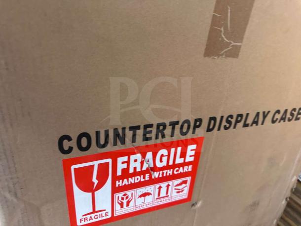 Brand new KoolMore DC-3CB bakery display case box, marked "Fragile" and "Countertop Display Case" for safe transport.