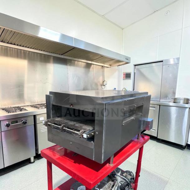 Star QT14 conveyor sandwich toaster oven in excellent condition on red stand; commercial kitchen setting.