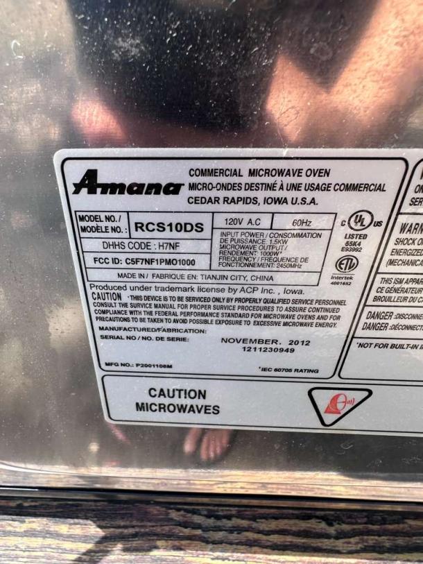 Amana RCS10DS commercial microwave oven label details, showing model number, power specs, and caution warnings. Stainless steel.