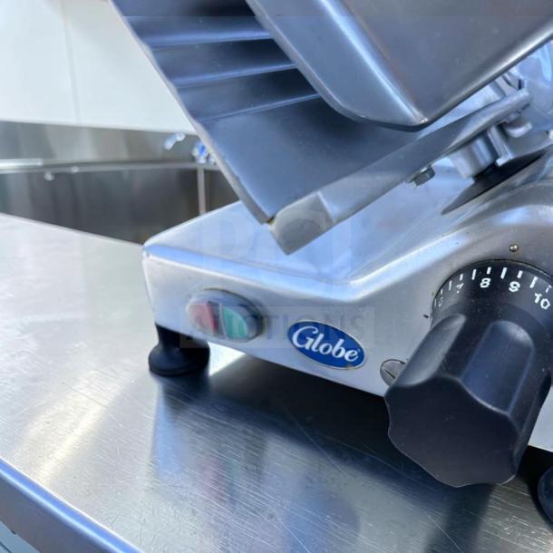 Globe G12 12" commercial meat slicer, elite condition, 1/2 HP, gravity feed, with control dial and Globe logo.