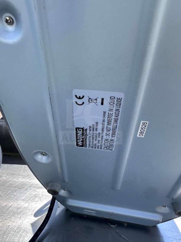 Waring WW180X Commercial Belgian Waffle Maker underside with label showing model, 120V rating, and caution instructions.