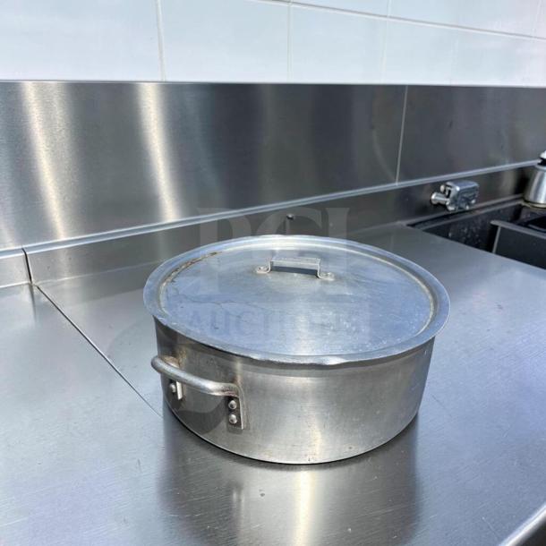 Heavy-duty aluminum stock pot with lid, large capacity, in superior condition, by Generic Commercial. Ideal for restaurants.