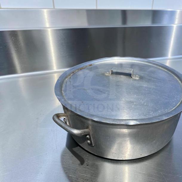 Heavy-duty commercial aluminum stock pot with lid, large capacity. Superior condition, inspected, ideal for restaurant use.